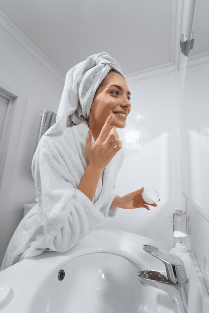 Woman applying sleeping mask to her face in her bathroom