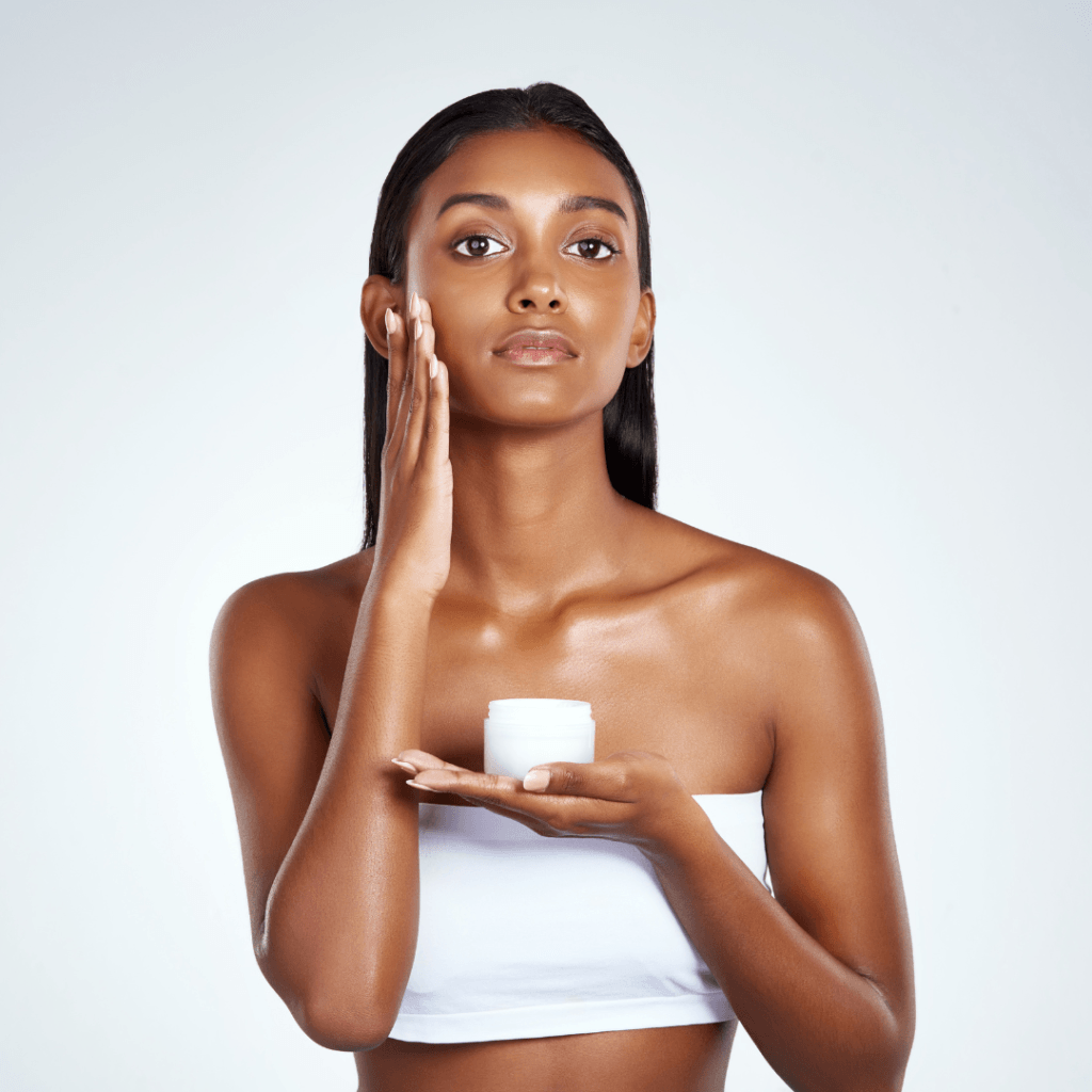 A woman applying face cream