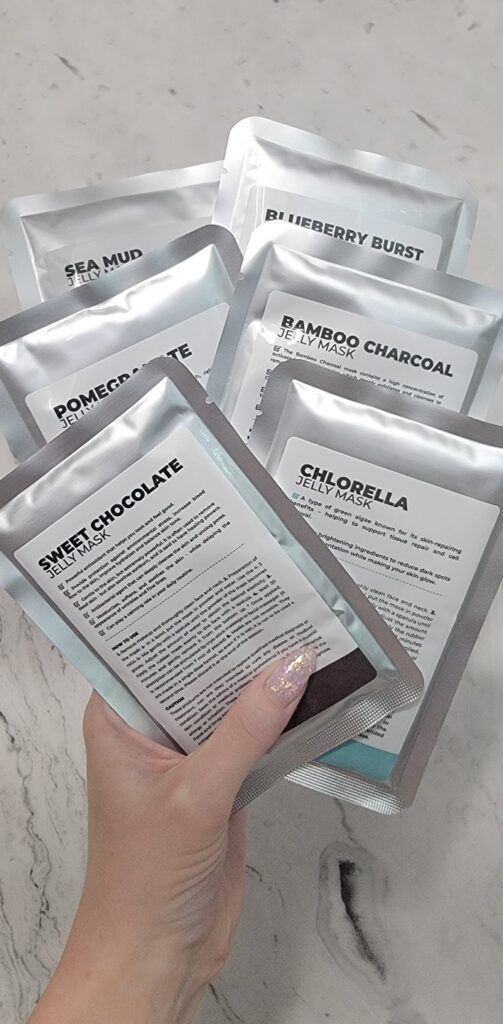 A hand holding a pack of individual jelly mask mixes